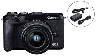  Front view of the Canon EOS M6 Mark II with lens attached, next to it on the right are charger and cable  
